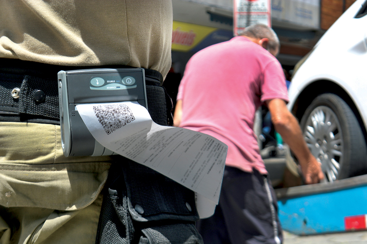 Impressão da multa enquanto carro é rebocado no Centro, nesta quinta (Fotos: Henrique Pinheiro)