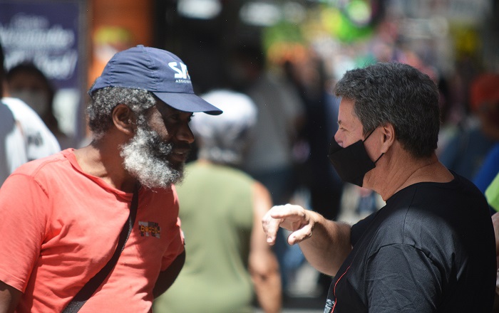Um homem sem e o outro com máscara conversam (Fotos: Henrique Pinheiro)